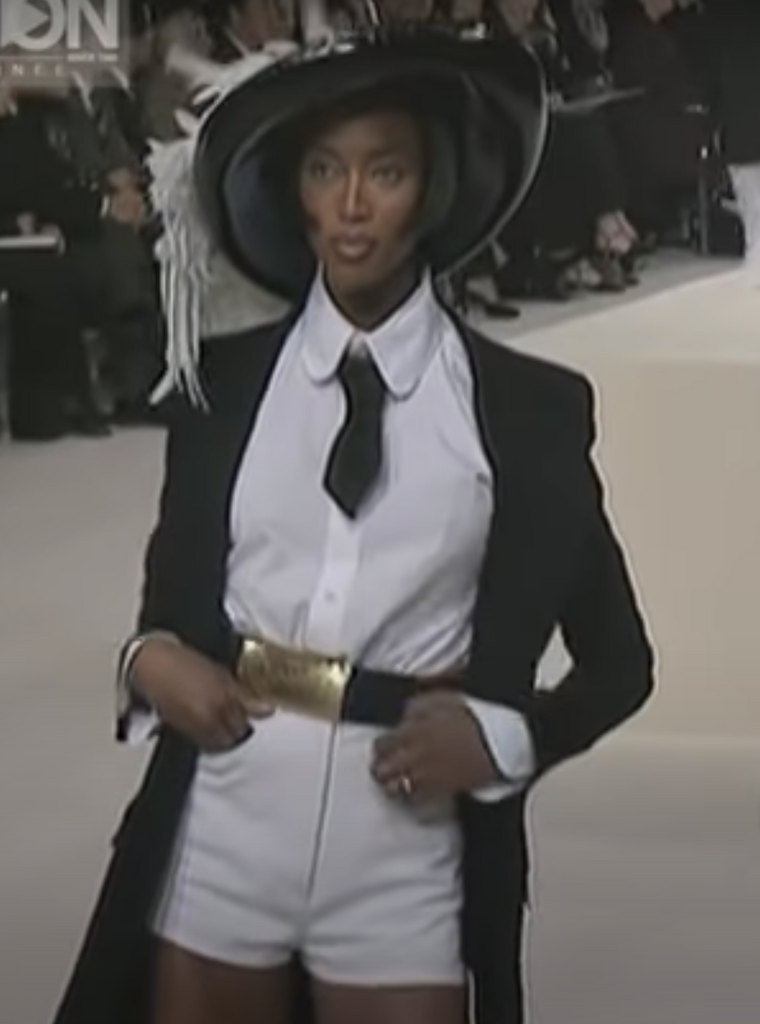 A rare, large Chanel Logo Waist Belt from 1997 -as worn on the runway by Naomi Campbell and Stella Tenant. It features a very large gold bar with CHANEL logo at the front, internal logo foil stamp and date, and gold buckle at rear.