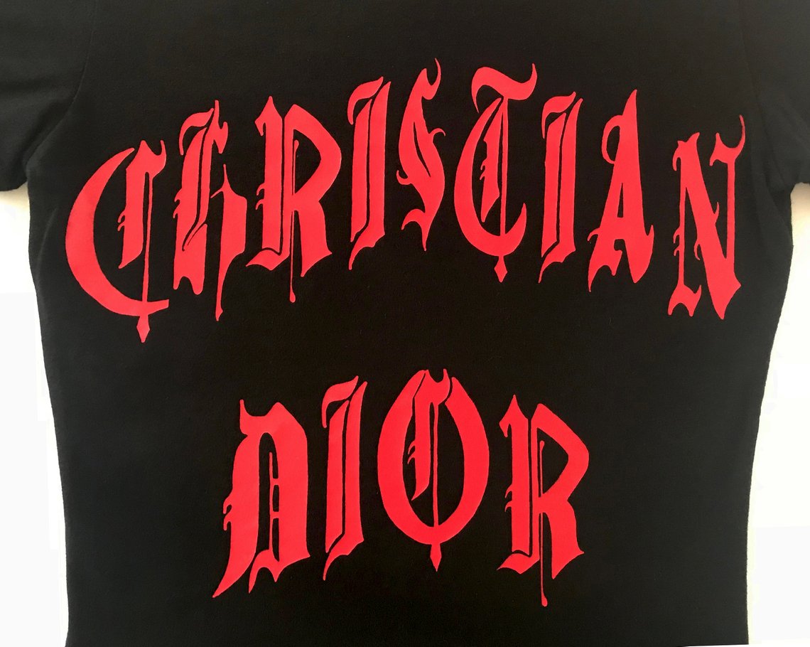 Fruit Vintage Christian Dior Gothic text Logo t-shirt. Features a classic t-shirt cut and graphic print with Christian Dior across the front and 1947 across the back.