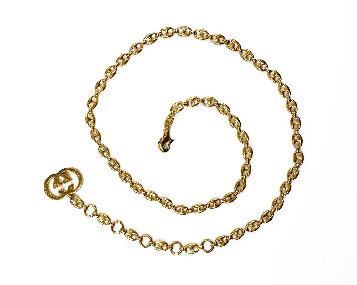 Fruit Vintage Gucci 1980s logo chain belt in classic gold. Features a lobster clip closure and significant logo drop Gucci GG charm. Looks incredible when worn as a necklace.