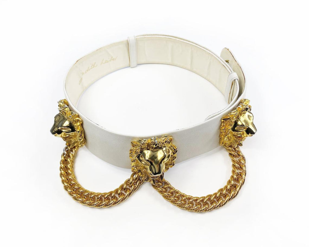 Fruit Vintage iconic Judith Leiber lion head belt with drop chains. This piece is amazing! It features 3 very large gold tone metal lions heads with drop chains on a white leather belt.