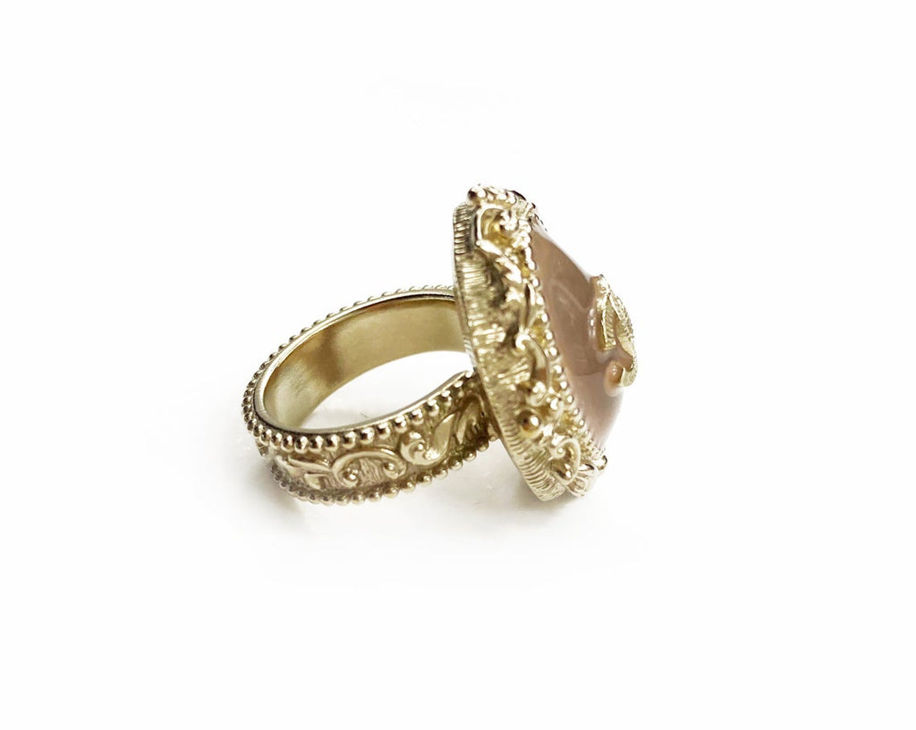 Fruit Vintage Chanel glass set logo ring. Features an ornate filigree style setting with pale pink glass stone with large CC logo inset.