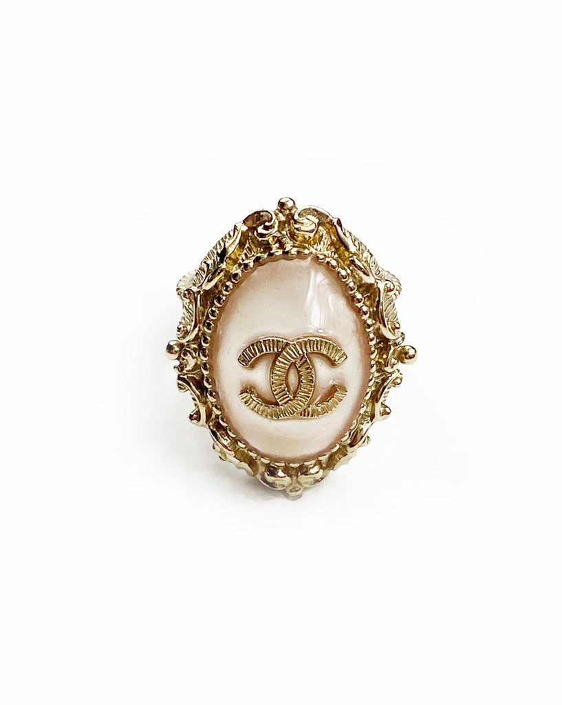 Fruit Vintage Chanel glass set logo ring. Features an ornate filigree style setting with pale pink glass stone with large CC logo inset.