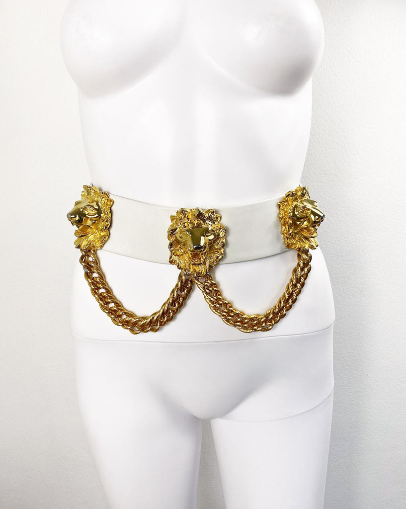 Fruit Vintage iconic Judith Leiber lion head belt with drop chains. This piece is amazing! It features 3 very large gold tone metal lions heads with drop chains on a white leather belt.