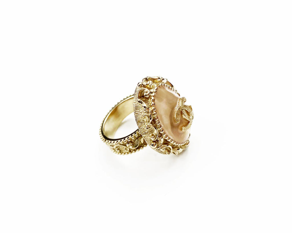 Fruit Vintage Chanel glass set logo ring. Features an ornate filigree style setting with pale pink glass stone with large CC logo inset.