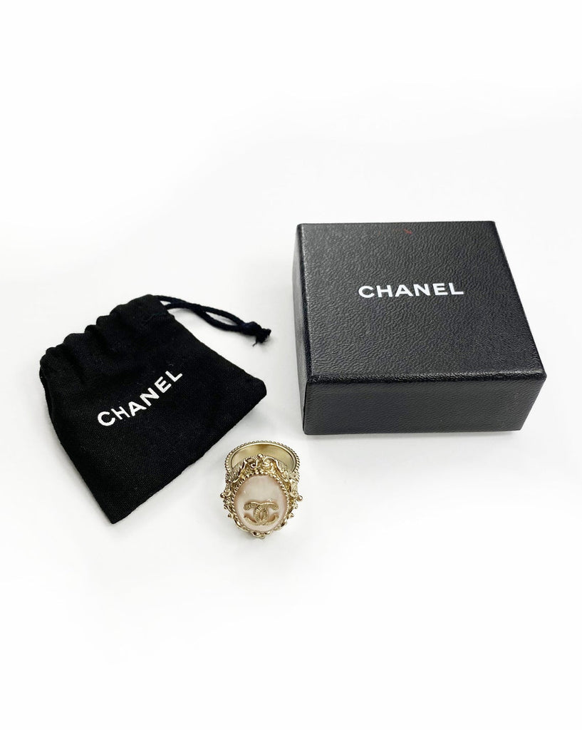 Fruit Vintage Chanel glass set logo ring. Features an ornate filigree style setting with pale pink glass stone with large CC logo inset.