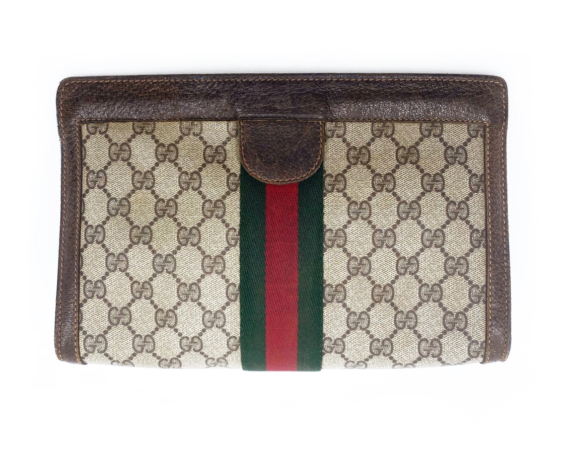 FRUIT Vintage Gucci 1980s Logo monogram canvas clutch bag. It features the iconic Gucci logo coated canvas, green and red fabric stripe, and velcro top closure.