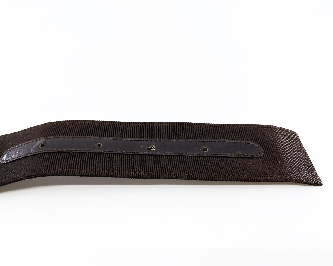 Fruit Vintage Salvatore Ferragamo 1980s bow belt in dark brown gross grain fabric. It features the iconic Ferragamo bow design with a large logo plate at front.