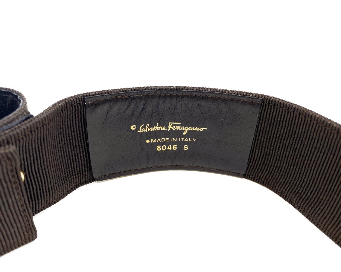 Fruit Vintage Salvatore Ferragamo 1980s bow belt in dark brown gross grain fabric. It features the iconic Ferragamo bow design with a large logo plate at front.