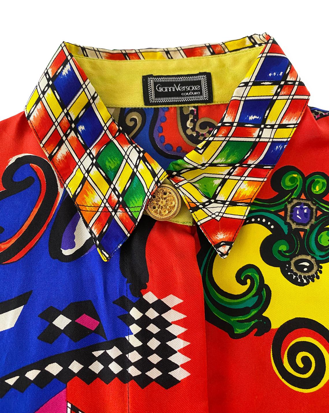 FRUIT Vintage Gianni Versace Vogue print silk short sleeve shirt from the Spring 1991 collection (as worn by Christy Turlington on the Runway). It features the iconic Vogue print in large scale all over and gold feature button on collar.