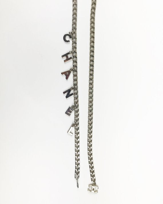 Fruit Vintage Chanel logo monogram letter chain belt in classic silver. Features a hook closure and logo drop Chanel CC charm.