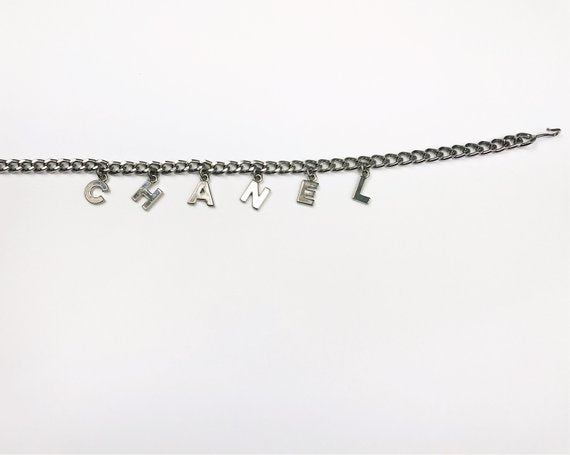 Fruit Vintage Chanel logo monogram letter chain belt in classic silver. Features a hook closure and logo drop Chanel CC charm.