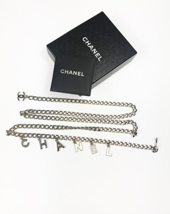 Fruit Vintage Chanel logo monogram letter chain belt in classic silver. Features a hook closure and logo drop Chanel CC charm.