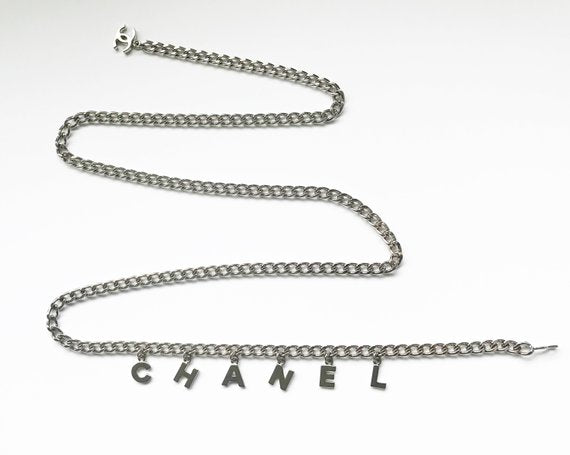 Fruit Vintage Chanel logo monogram letter chain belt in classic silver. Features a hook closure and logo drop Chanel CC charm.
