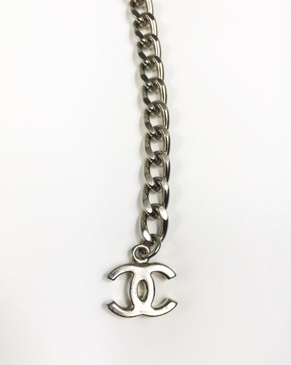 Fruit Vintage Chanel logo monogram letter chain belt in classic silver. Features a hook closure and logo drop Chanel CC charm.