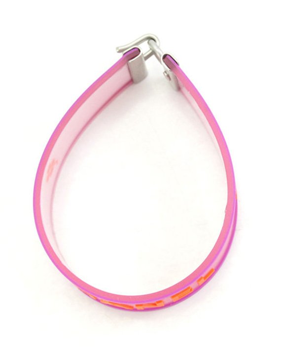 Fruit Vintage Chanel pink and orange rubber logo cuff bracelet with large CHANEL text logo to the centre and two clover symbols either side.