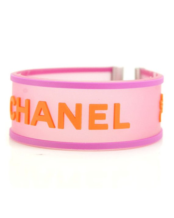 Fruit Vintage Chanel pink and orange rubber logo cuff bracelet with large CHANEL text logo to the centre and two clover symbols either side.