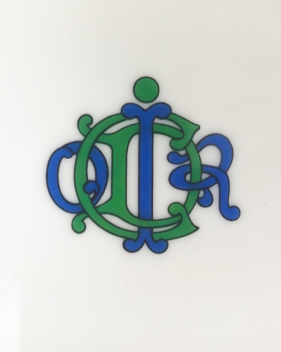 FRUIT Vintage Christian Dior very rare porcelain change tray featuring the 1980s logo in the center surrounded by vibrant green and blue tones and floral motifs.