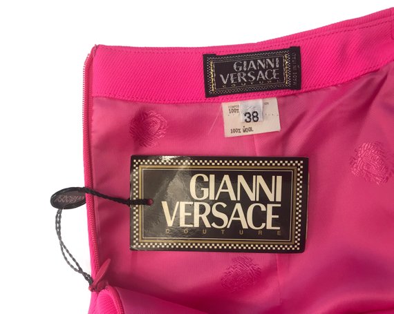 FRUIT Vintage neon pink lifetime Gianni Versace skirt with the original tags still attached. This piece dates to 1996 and features a classic slim fit and high waist design.