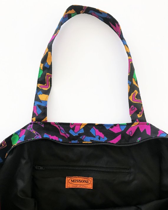 Fruit Vintage 1980s Missoni beach bag in a psychedelic logo printed nylon fabric. Features a zipper closure at top and internal zipped pocket.