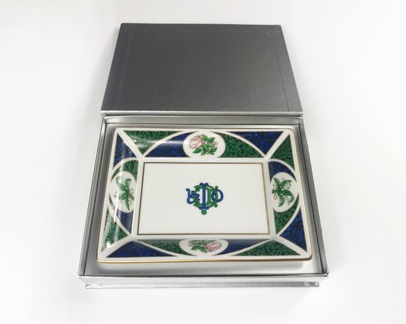 FRUIT Vintage Christian Dior very rare porcelain change tray featuring the 1980s logo in the center surrounded by vibrant green and blue tones and floral motifs.