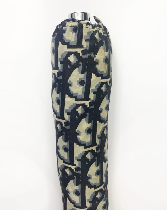 FRUIT vintage Christian Dior navy oblique logo umbrella dating to the late 1970s-early 1980s. This compact umbrella is in working condition with a matching cover, features the classic Christian Dior trotter/oblique print all over, Christian Dior logo text, telescoping stick and faux wood handle.