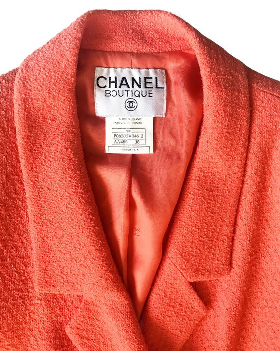 Fruit Vintage Chanel boucle jacket in pale neon peach tone. This jacket is from the famous Spring/Summer 1996 RTW collection by Karl Lagerfeld. It features a longer-line length, classic Chanel logo buttons, internal chain hem and two front pockets.