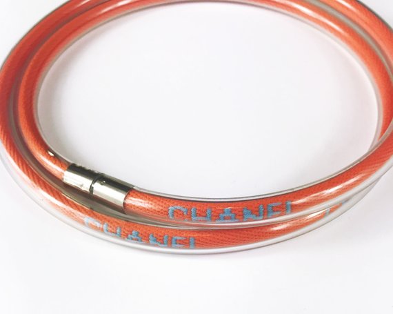 Fruit Vintage Chanel orange wrap around rubber tubing choker with CHANEL text logo all around.