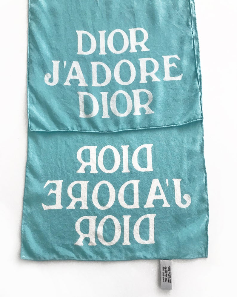 FRUIT vintage Christian Dior rare J'adore Dior logo monogram silk scarf perfect for use as a hair accessory, to tie around a hat or when worn around the neck. Features a bold graphic Dior logo print on both ends and hand finished rolled hem edging