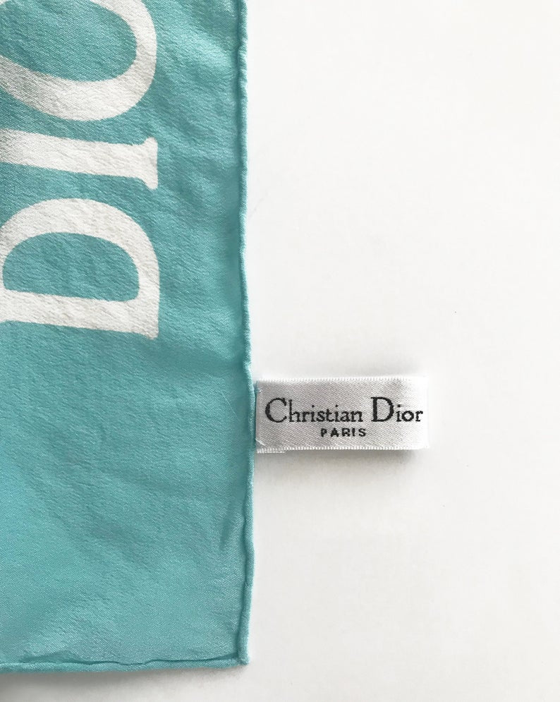 FRUIT vintage Christian Dior rare J'adore Dior logo monogram silk scarf perfect for use as a hair accessory, to tie around a hat or when worn around the neck. Features a bold graphic Dior logo print on both ends and hand finished rolled hem edging