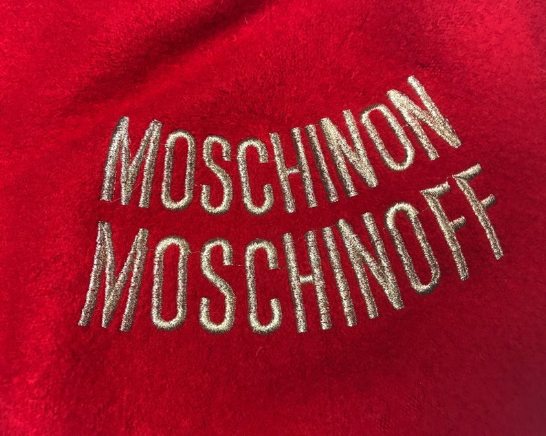 FRUIT Vintage Moschino logo beret hat. It features large embroidered gold text with the slogal "Moschinon Moschinoff" and a classic beret hat shape.