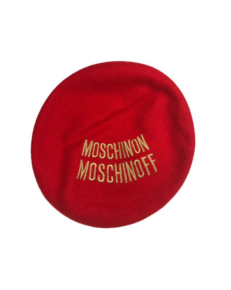 FRUIT Vintage Moschino logo beret hat. It features large embroidered gold text with the slogal "Moschinon Moschinoff" and a classic beret hat shape.