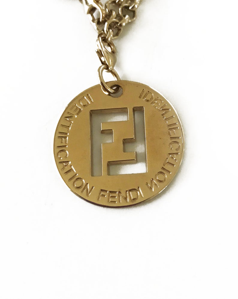 FRUIT Vintage Fendi zucca logo charm necklace in excellent condition. Features 2 removable charm pendants, one with cut-out Fendi logo F's and a second with crystal embellished bow symbol