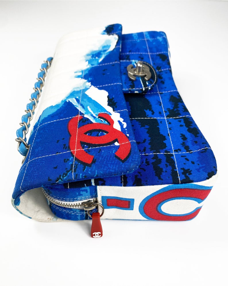 Fruit Vintage Chanel quilted surf print logo canvas flap bag. Features a graphic blue and white surf/wave print on canvas, a square quilted stitching design, classic Chanel flap and zipper closure with Chanel logo pull.