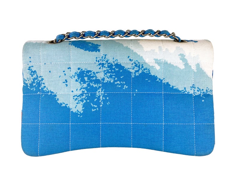 Fruit Vintage Chanel quilted surf print logo canvas flap bag. Features a graphic blue and white surf/wave print on canvas, a square quilted stitching design, classic Chanel flap and zipper closure with Chanel logo pull.
