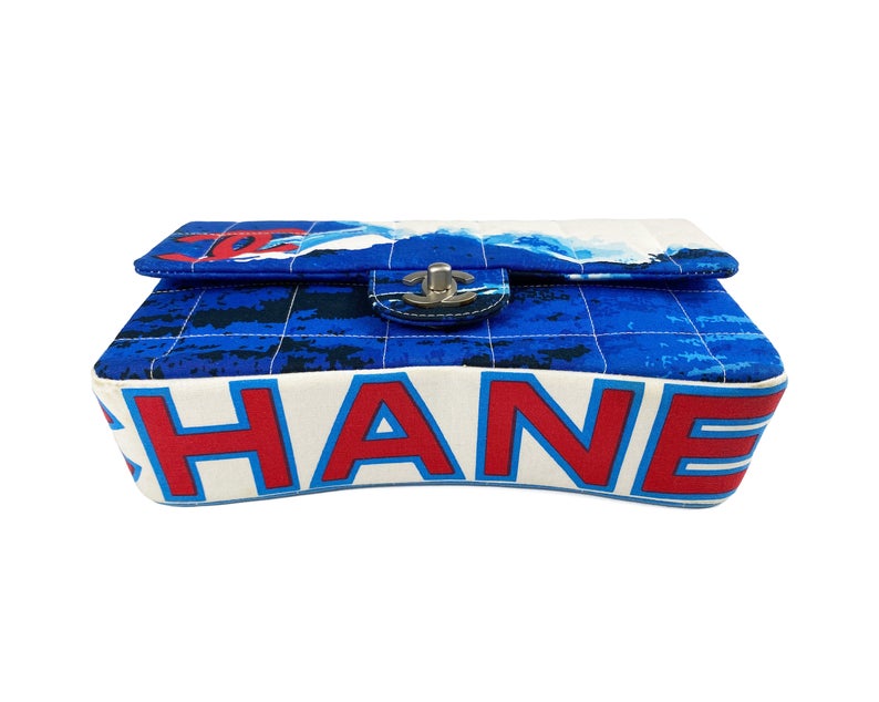 Fruit Vintage Chanel quilted surf print logo canvas flap bag. Features a graphic blue and white surf/wave print on canvas, a square quilted stitching design, classic Chanel flap and zipper closure with Chanel logo pull.