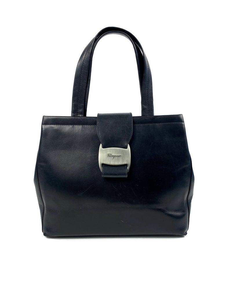 FRUIT Vintage 1980s Salvatore Ferragamo bag in black leather. This is such an elegant bag, in an iconic Ferragamo shape. Features a classic Ferragamo logo buckle closure, internal zipper pocket with logo pull and logo lining.