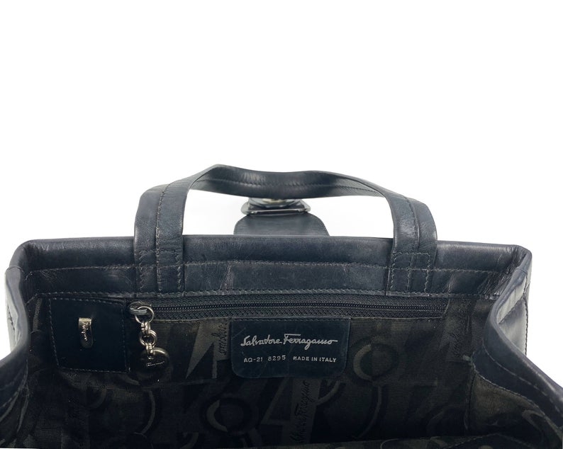 FRUIT Vintage 1980s Salvatore Ferragamo bag in black leather. This is such an elegant bag, in an iconic Ferragamo shape. Features a classic Ferragamo logo buckle closure, internal zipper pocket with logo pull and logo lining.