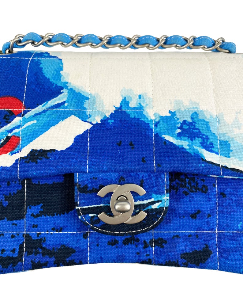 Fruit Vintage Chanel quilted surf print logo canvas flap bag. Features a graphic blue and white surf/wave print on canvas, a square quilted stitching design, classic Chanel flap and zipper closure with Chanel logo pull.