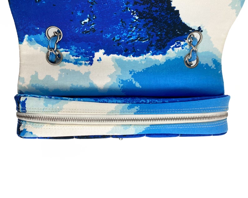Fruit Vintage Chanel quilted surf print logo canvas flap bag. Features a graphic blue and white surf/wave print on canvas, a square quilted stitching design, classic Chanel flap and zipper closure with Chanel logo pull.