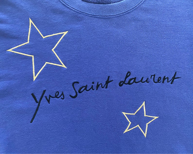 FRUIT Vintage Yves Saint Laurent logo star embroidered blue sweatshirt. Features a large text YSL logo at front and a classic 90's cut.