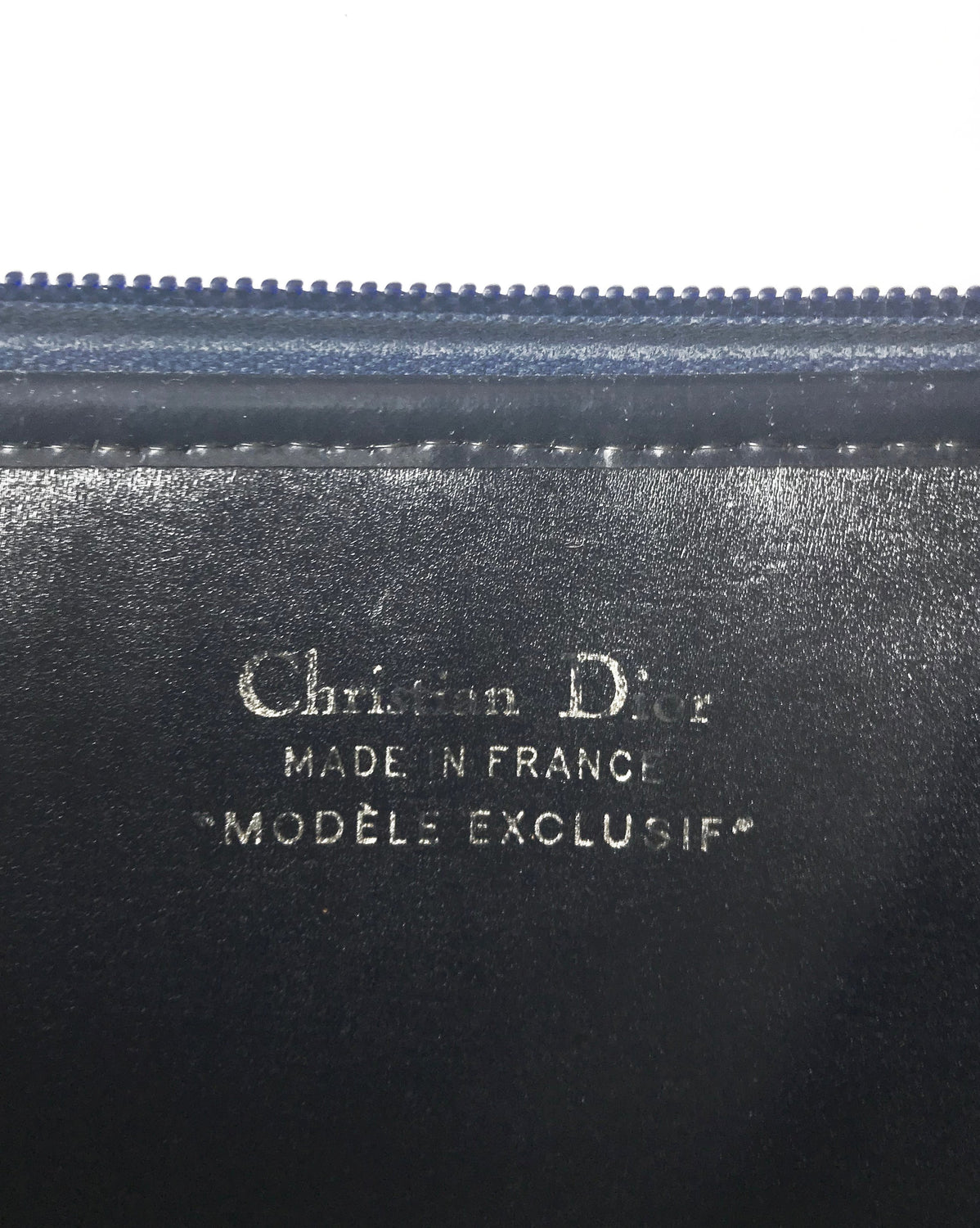 FRUIT Vintage Christian Dior 1980s navy trotter monogram clutch bag. Features a pochette style curved shape with top zipper and leather lining.