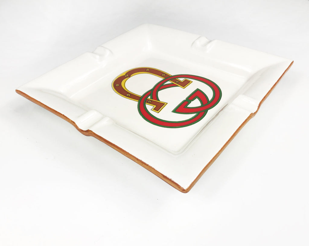 FRUIT Vintage Gucci hand painted 1980's porcelain logo ashtray or change tray. Features a classic ashtray shape, brown trim and Gucci suede logo fabric and mark at base. This is a very special piece!