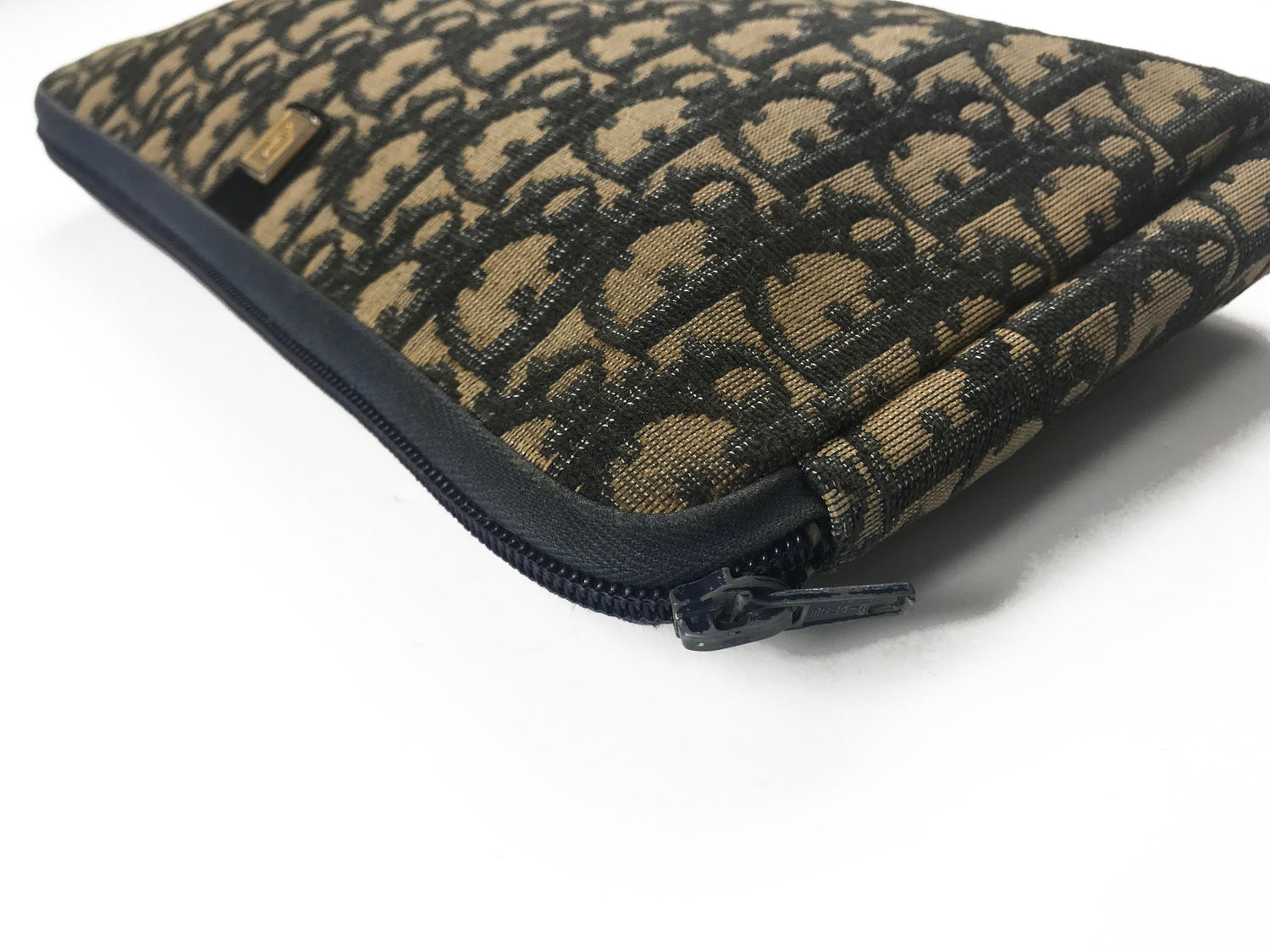 FRUIT Vintage Christian Dior 1980s navy trotter monogram clutch bag. Features a pochette style curved shape with top zipper and leather lining.