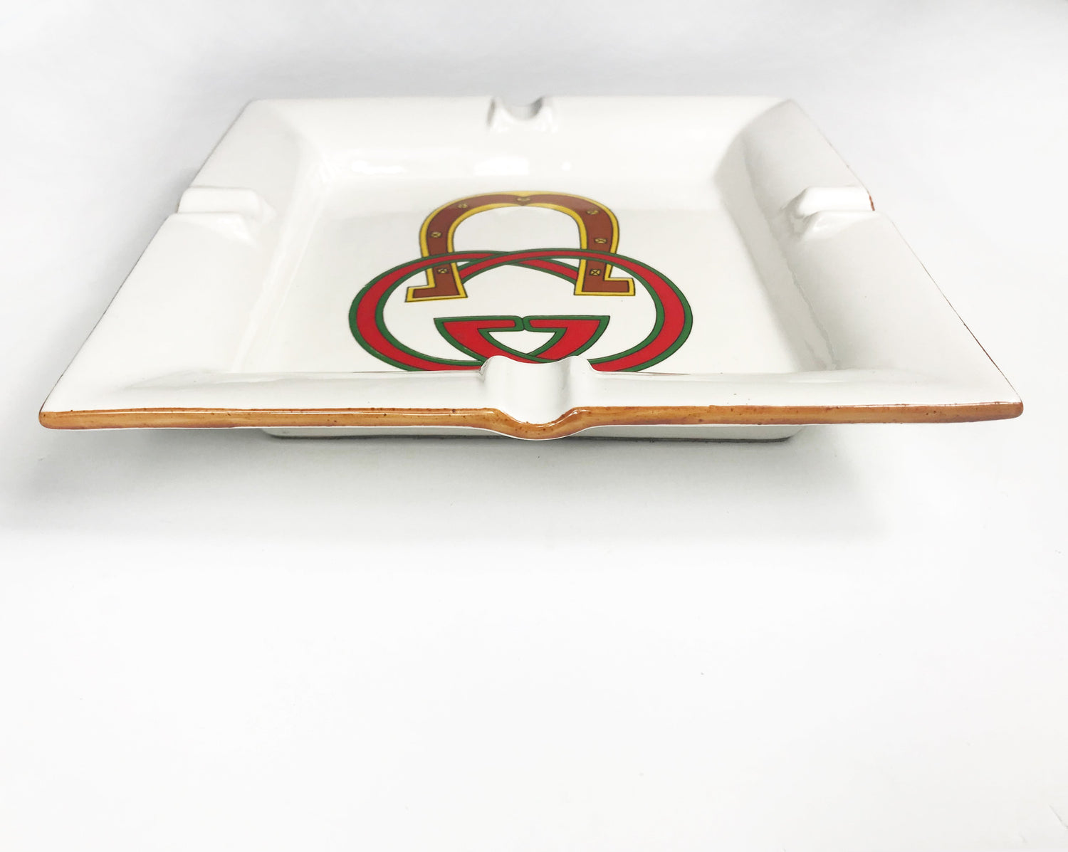 FRUIT Vintage Gucci hand painted 1980's porcelain logo ashtray or change tray. Features a classic ashtray shape, brown trim and Gucci suede logo fabric and mark at base. This is a very special piece!