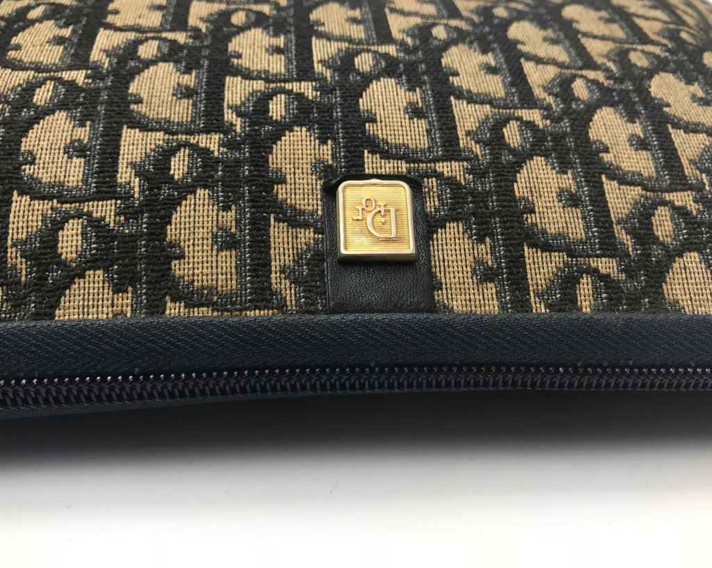 FRUIT Vintage Christian Dior 1980s navy trotter monogram clutch bag. Features a pochette style curved shape with top zipper and leather lining.