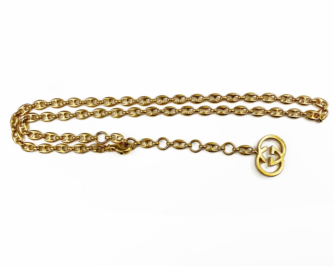 Fruit Vintage Gucci 1980s logo chain belt in classic gold. Features a lobster clip closure and significant logo drop Gucci GG charm. Looks incredible when worn as a necklace.