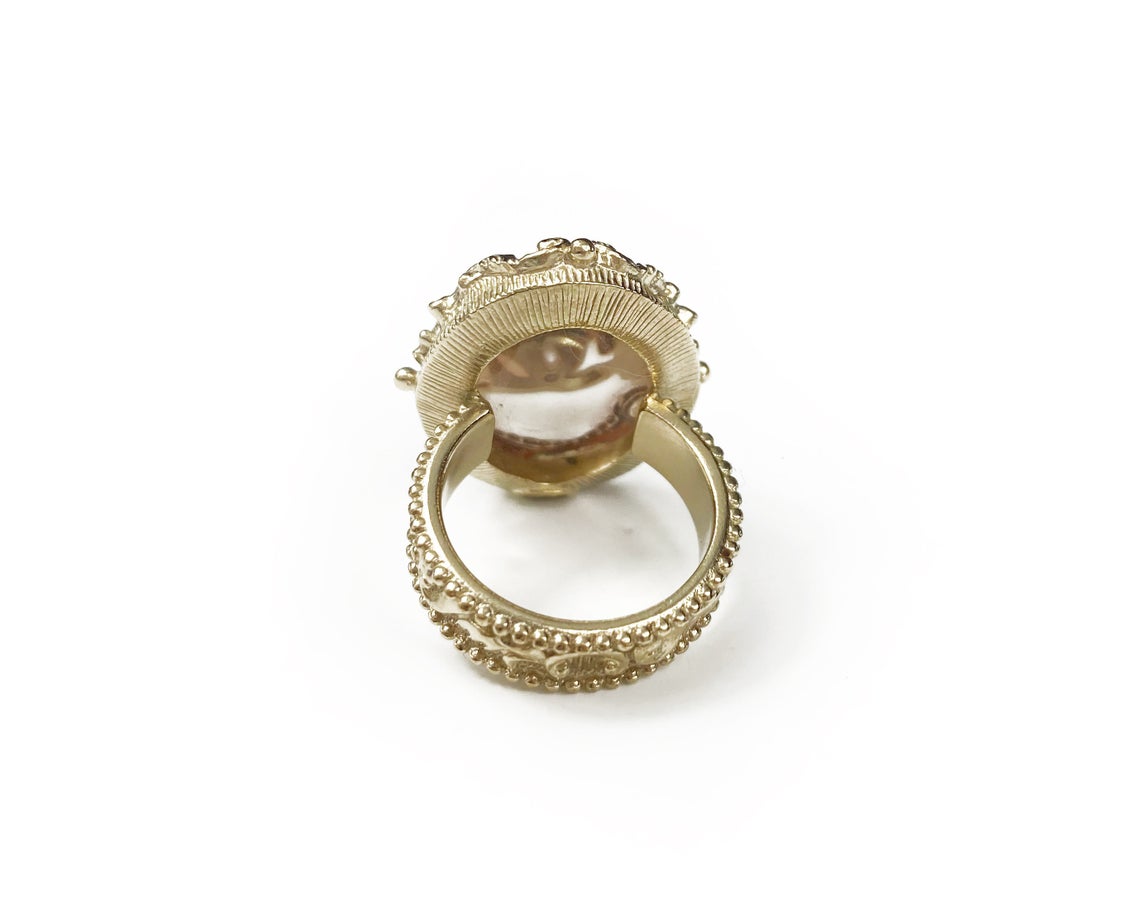 Fruit Vintage Chanel glass set logo ring. Features an ornate filigree style setting with pale pink glass stone with large CC logo inset.