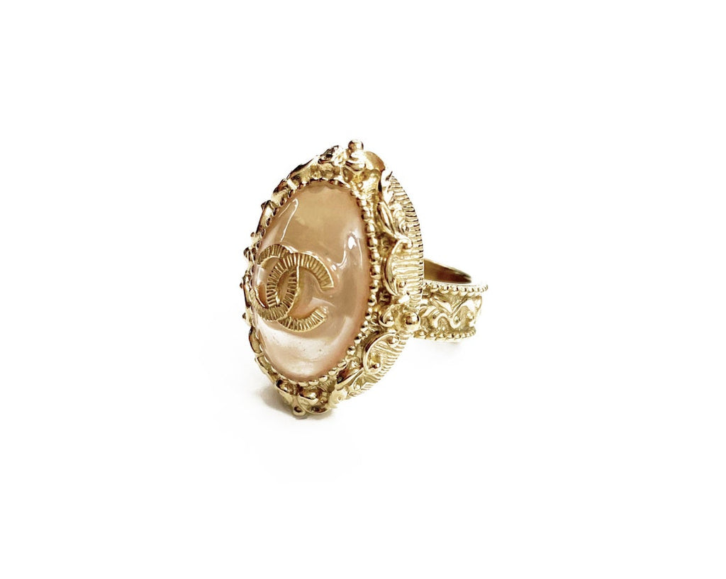 Fruit Vintage Chanel glass set logo ring. Features an ornate filigree style setting with pale pink glass stone with large CC logo inset.