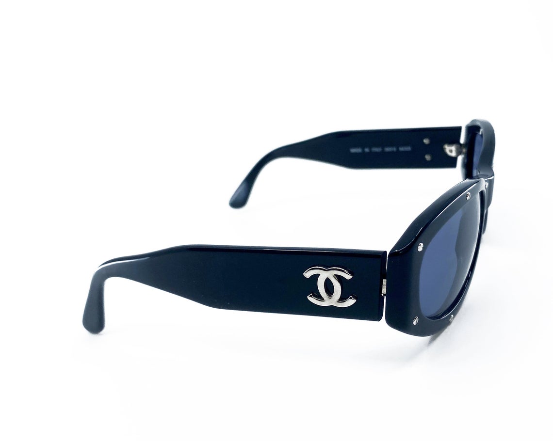 Fruit Vintage Chanel 1990s studded logo sunglasses. They feature silver screw shaped studs to the front of the frame and Chanel CC logo monograms to each side.