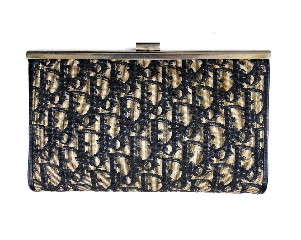 FRUIT vintage 1970s Christian Dior logo clutch bag is made of Navy Dior trotter print canvas and features a gold hardware clip top closure. 